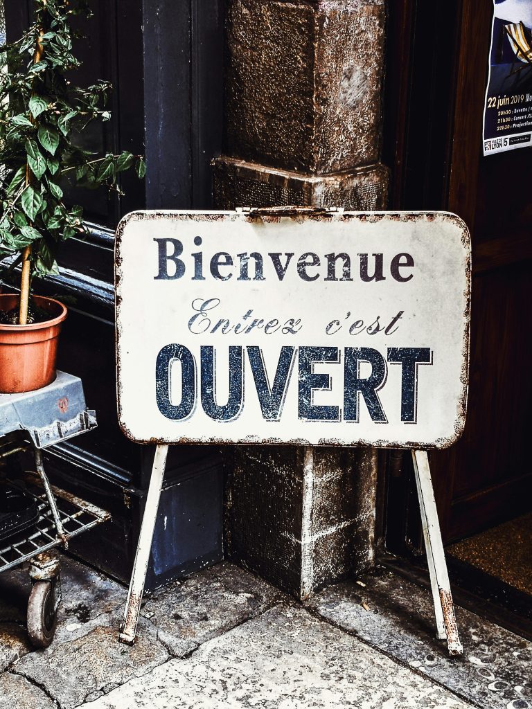 Rustic 'Ouvert' sign welcoming visitors in Lyon, France.